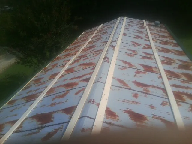 Rusted metal roof panels with new wood purlins before replacement — Storm Damage Roof Repair in Salemburg by Roofing Brothers