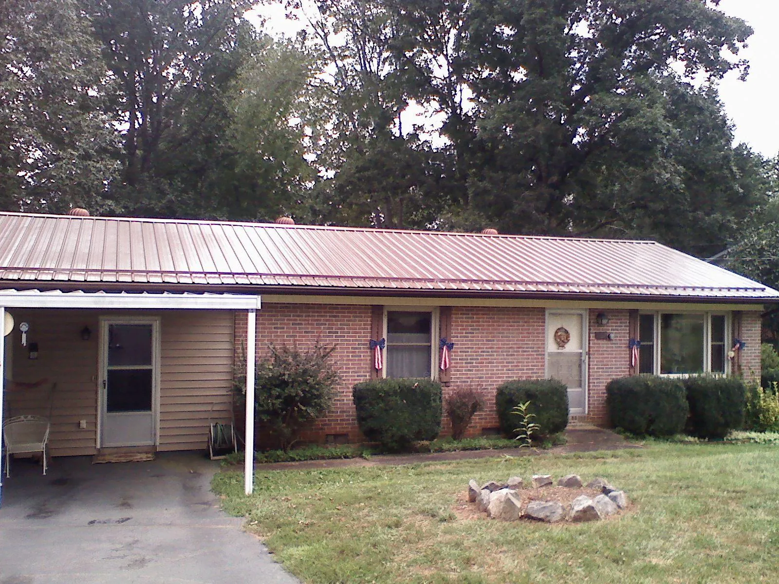 Bronze metal roof and carport on a brick ranch home — Roof Repair work by our crew in Salemburg